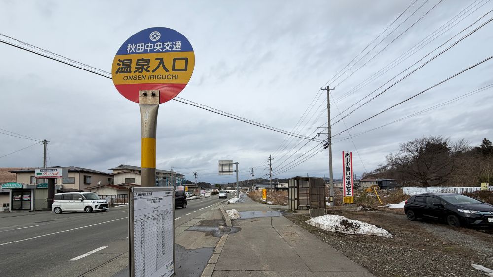 秋田中央交通「温泉入口」バス停と雪の残る街並み